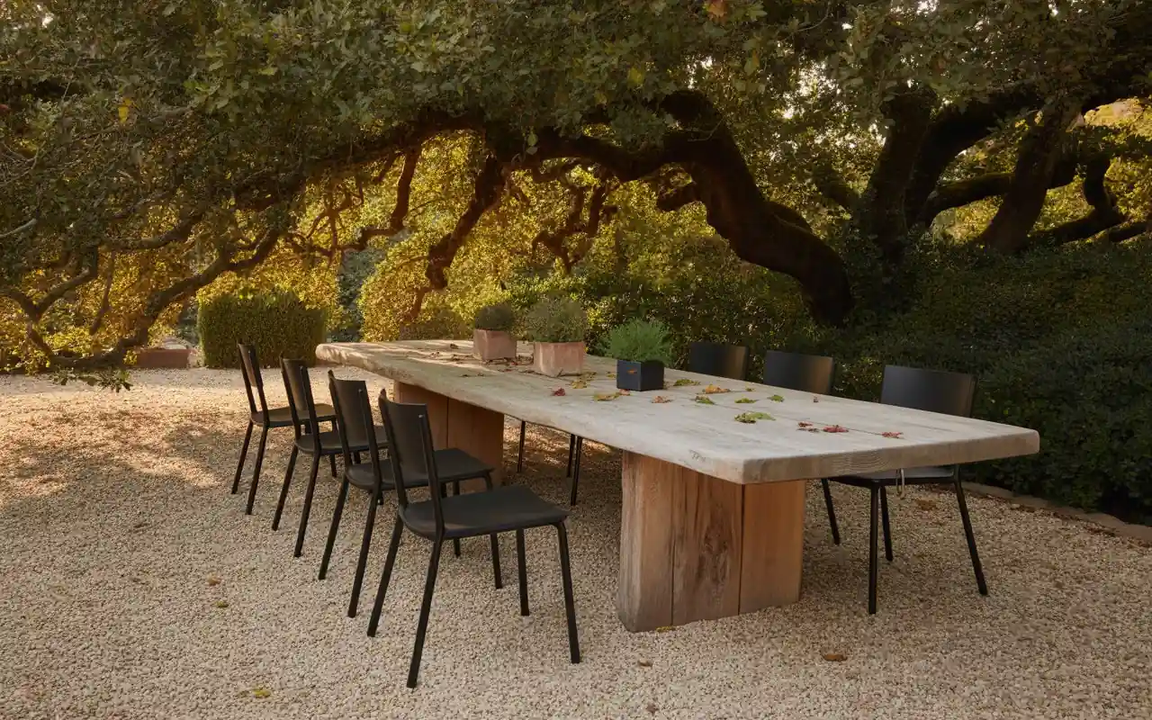 Warm Edison string lights crisscrossing over an outdoor patio with a seating area below.