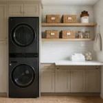 A luxurious tiny laundry room with white cabinets, gold hardware, and stacked appliances.
