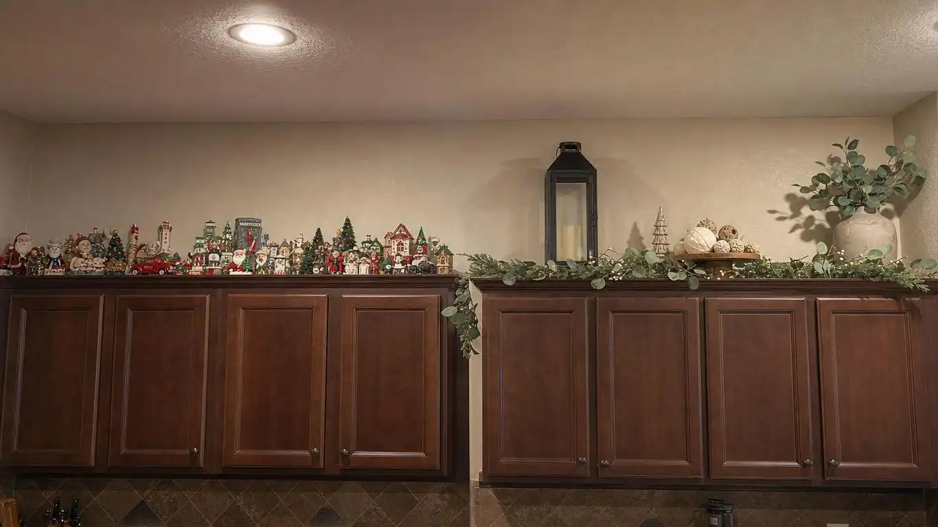 Polished Christmas kitchen island vignette with clustered decor at one end showing varied heights and limited materials