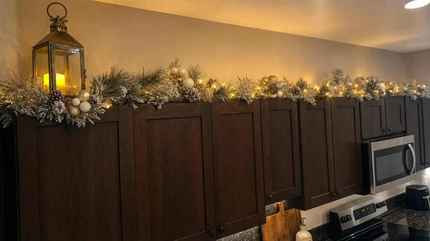 Narrow 28-inch kitchen island with a compact brass lantern and boxwood topiary vignette at one end for Christmas decor