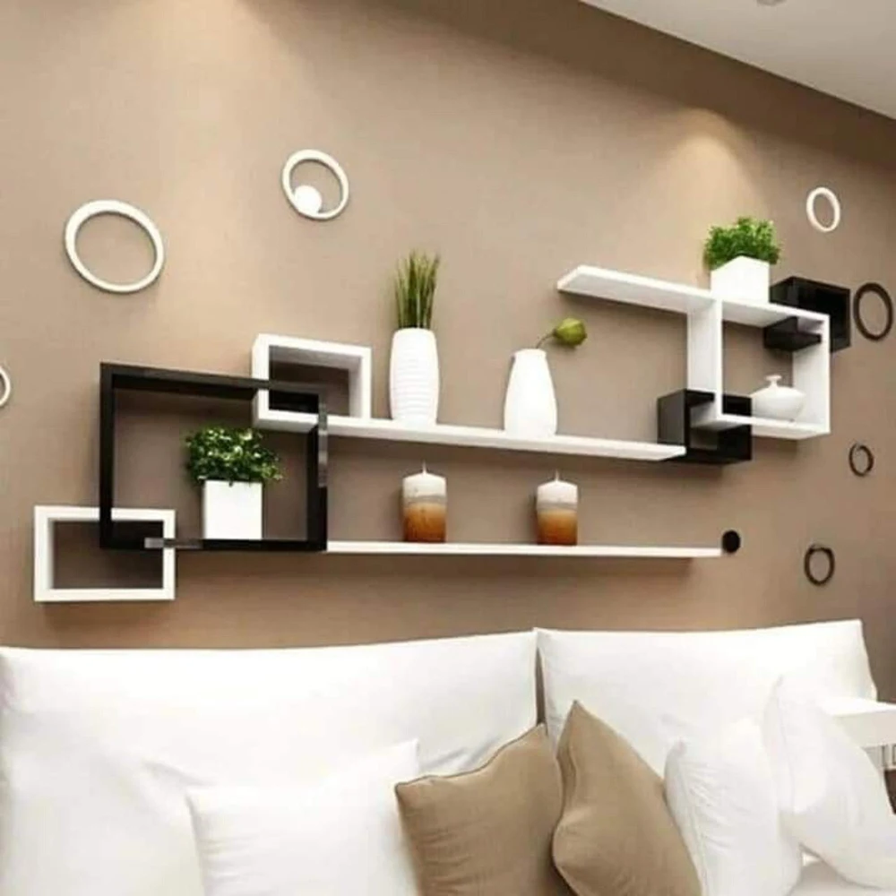 Two warm 2700K bedside table lamps on floating shelves flanking a studio apartment bed creating a separate light zone
