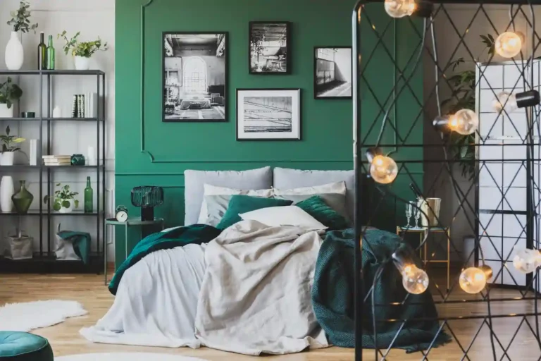 Layered bedroom with upholstered headboard, warm bedside lamps, framed art, and a rug floating past the bed
