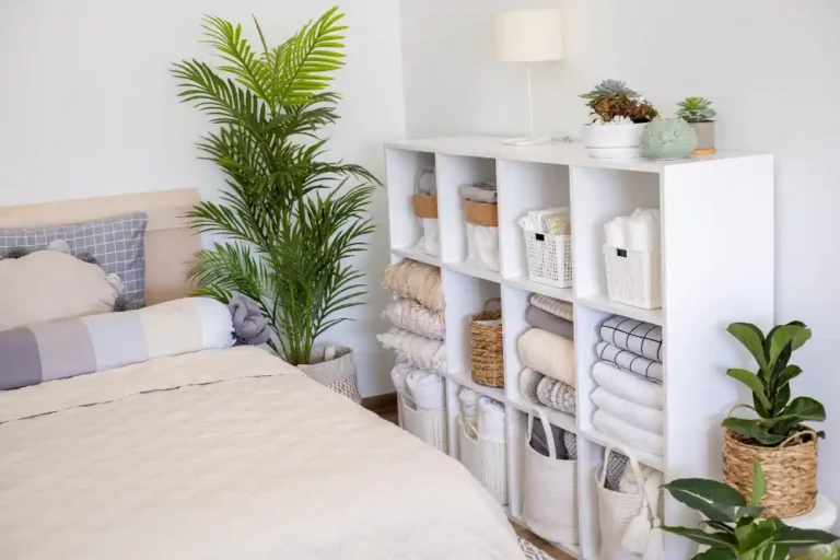 Calm styled bedroom with clear surfaces, a storage bench at the foot of the bed, and hidden storage