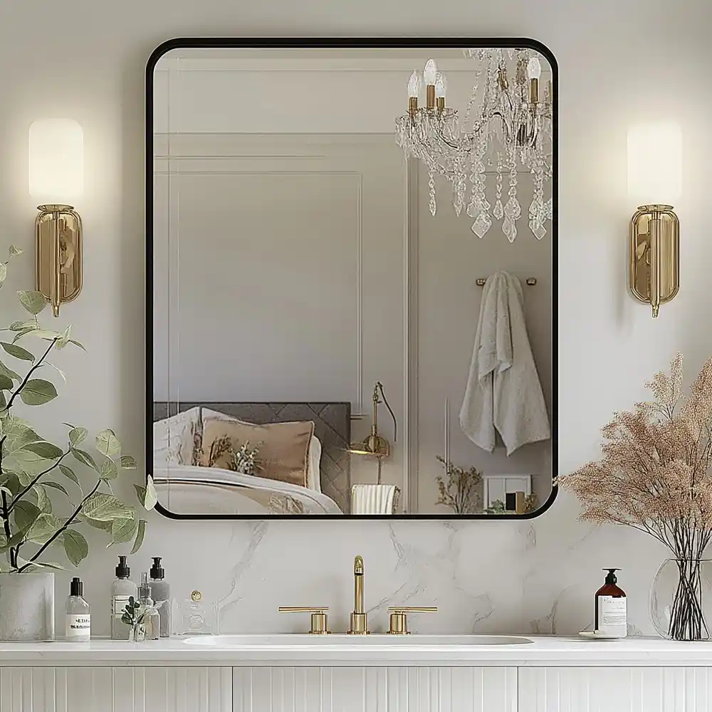 Close-up of brushed brass lamp base and antique gold mirror frame in a women's bedroom