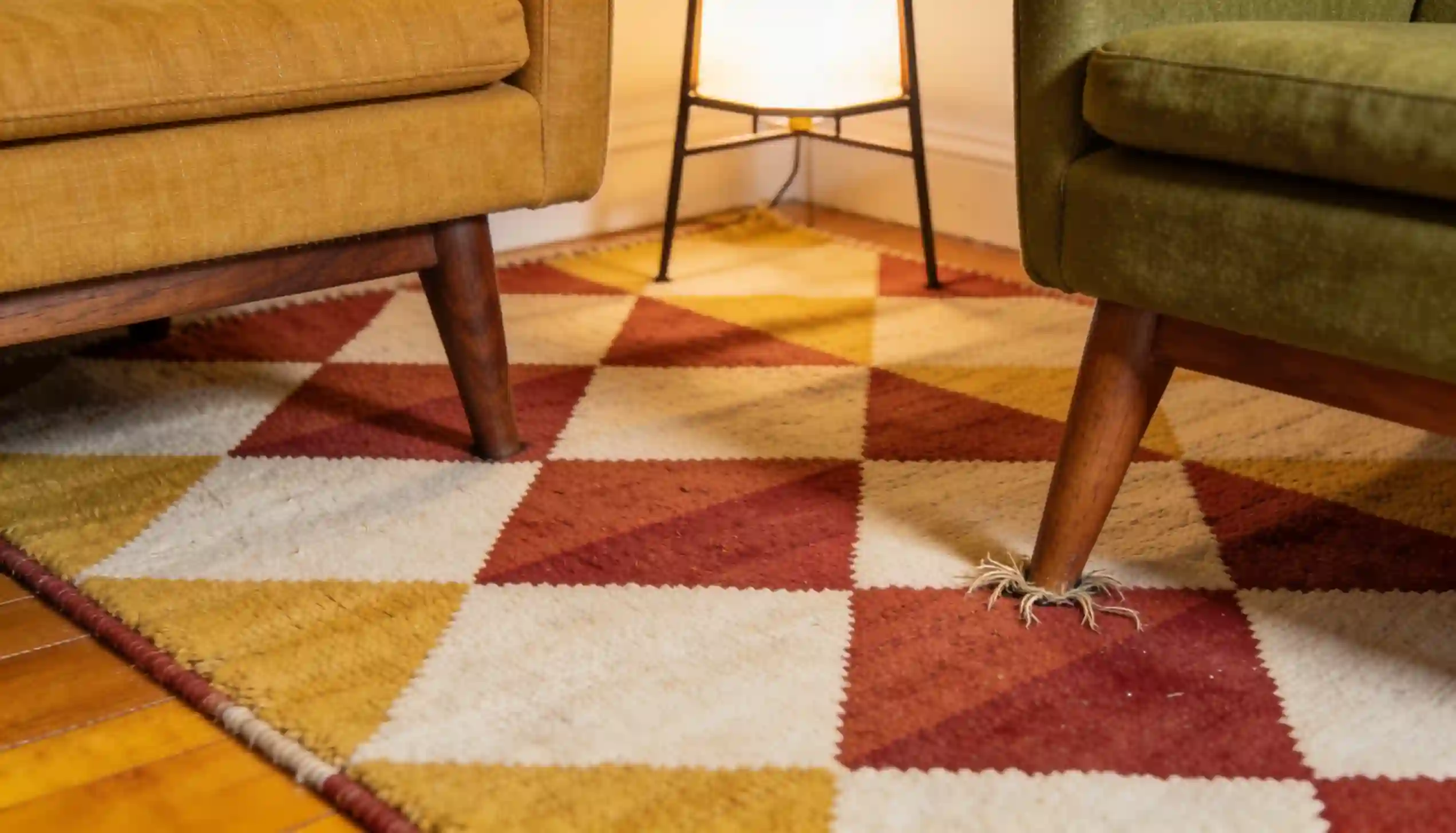 Close-up of brushed brass floor lamp and copper side table accents in a colorful mid century modern living room corner