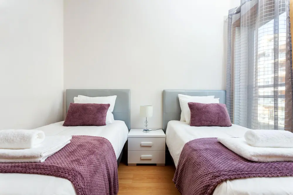 Twin XL dorm mattress with white cotton fitted sheet showing the 38x80 inch size in a standard college dorm room