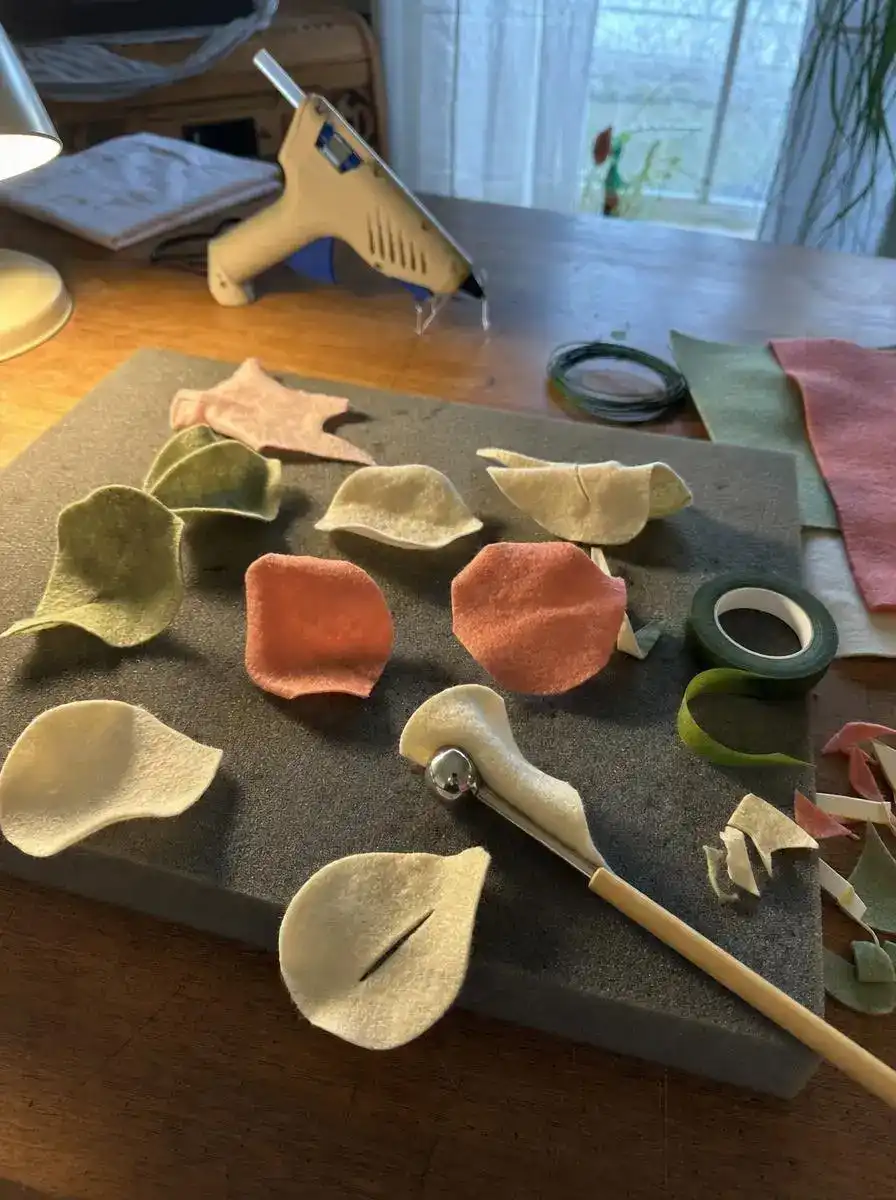Felt flower craft ideas in progress, shaping and curling petals with a stylus on a foam mat