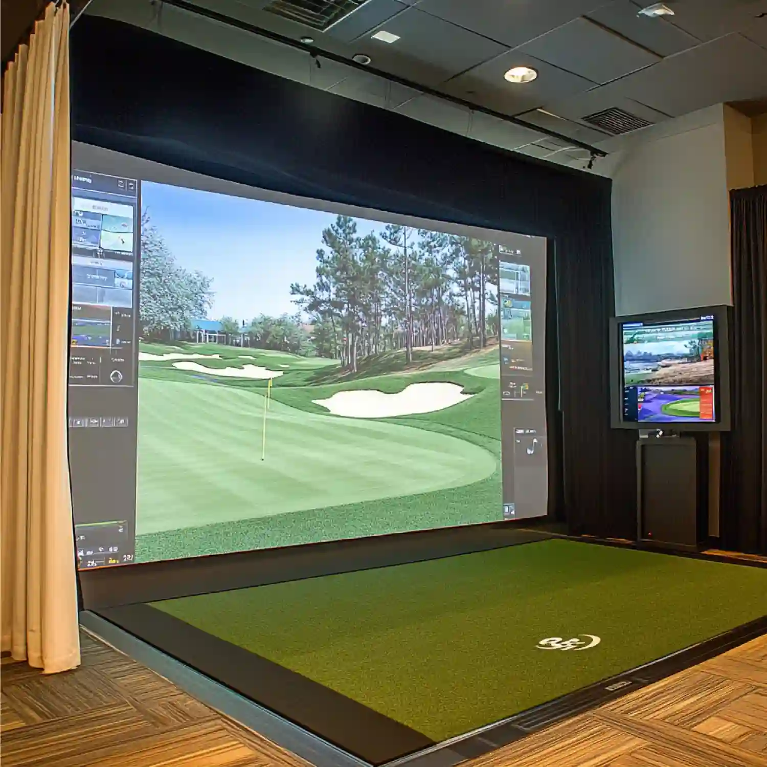 Golf simulator man cave bay with impact screen, enclosure frame, and projector mounted to ceiling in a dark finished room