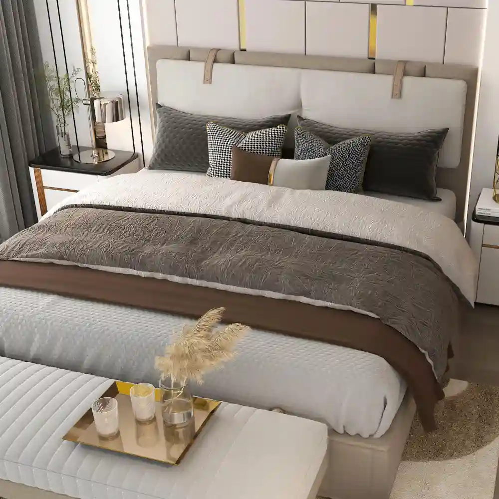 Bed styled with cream linen duvet, euro shams, lumbar pillow, and a folded knit throw across the foot