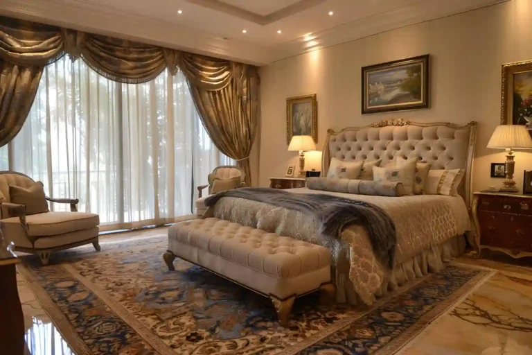 Calm luxurious bedroom with tall upholstered headboard, warm lamps, floor-length curtains, and a large rug under the bed