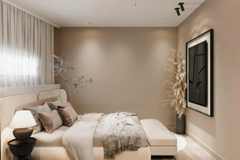 Small bedroom painted in warm greige with linen bedding, oak nightstand, and soft natural light from one window
