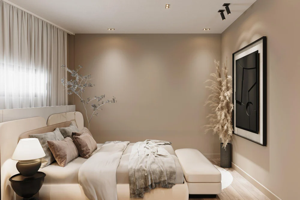Small bedroom painted in warm greige with linen bedding, oak nightstand, and soft natural light from one window