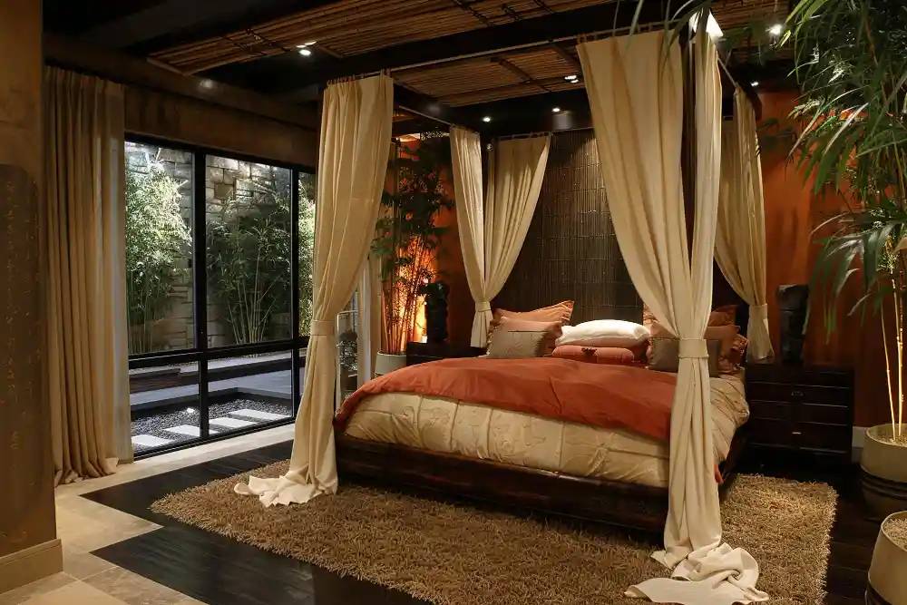 Calm studio apartment with a curtain-divided sleeping zone, linen bedding, and warm 2700K bedside lamps
