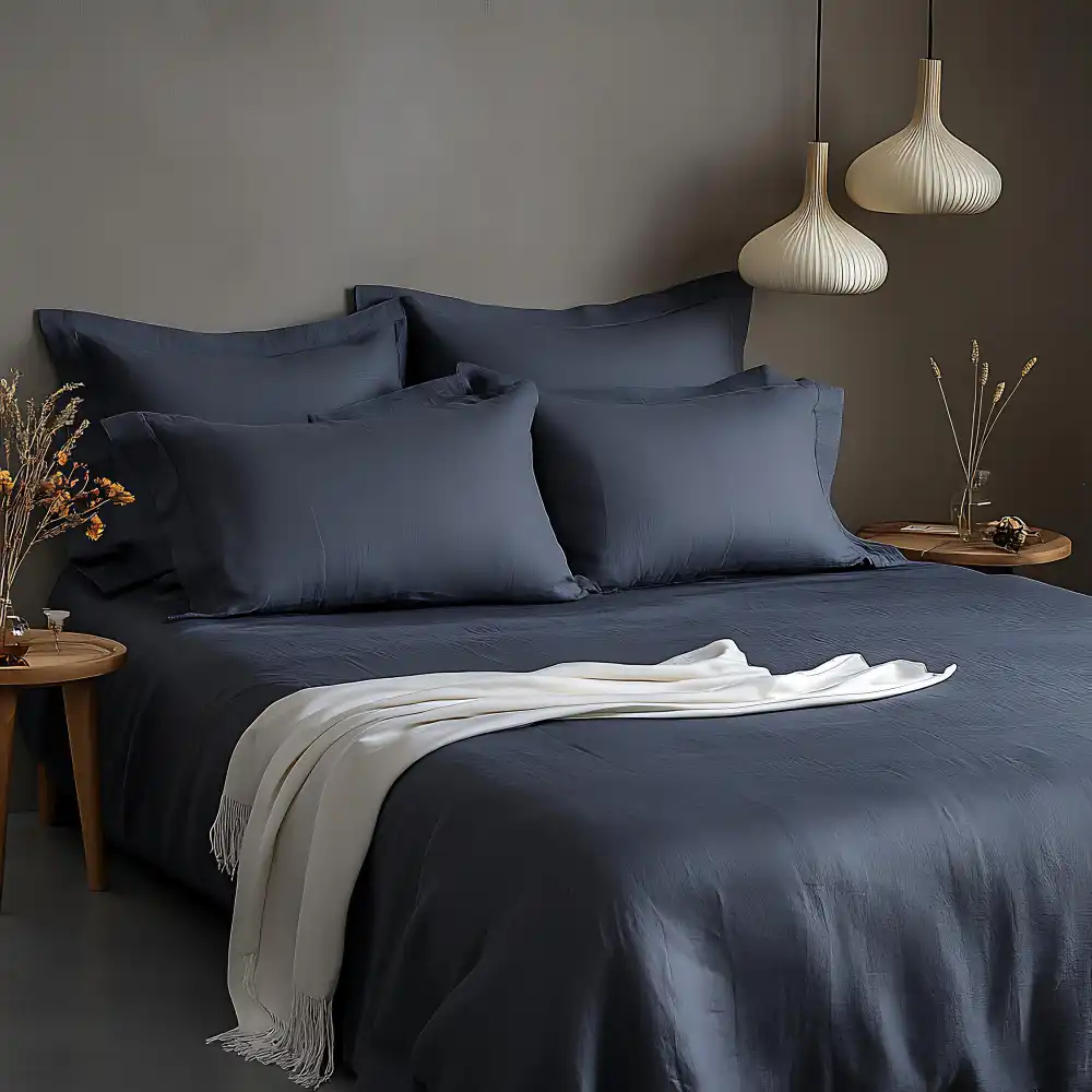 Tailored masculine bedding with a crisp charcoal duvet, two sleeping pillows, and one lumbar pillow