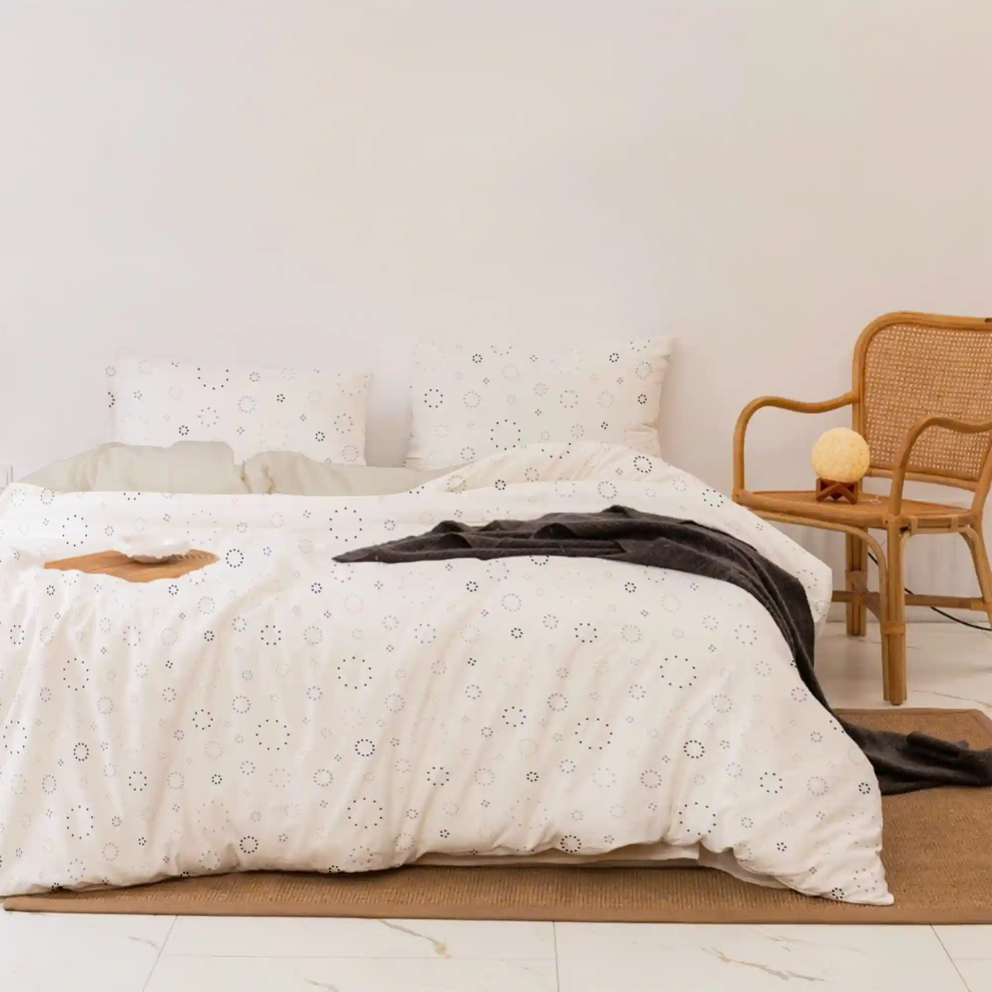 Crisp white 100% cotton Twin XL sheet set neatly made on a dorm bed with a neutral cream pillow