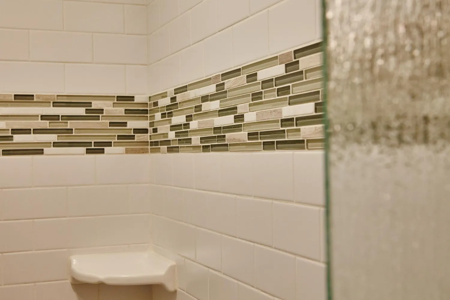 Glossy handmade zellige tile wall in warm white catching light behind a bathroom sink