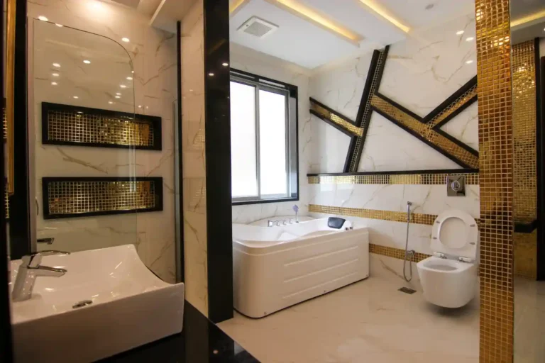 Modern bathroom with floating oak vanity, matte black taps, large-format tile, and warm 3000K lighting