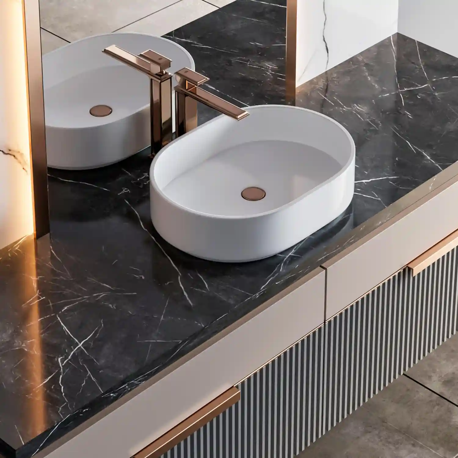 Close-up of a veined marble and quartz vanity top with brushed brass pulls on a green cabinet