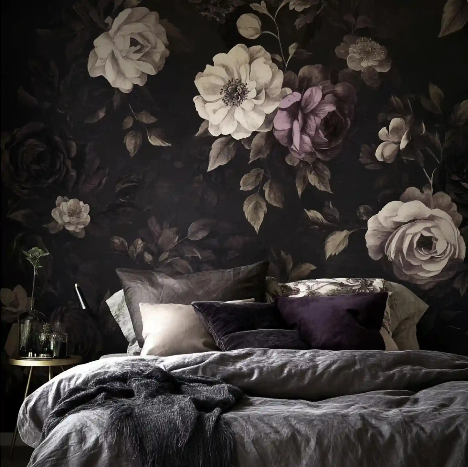 Large-scale gold floral wallpaper on a charcoal ground behind an upholstered bed