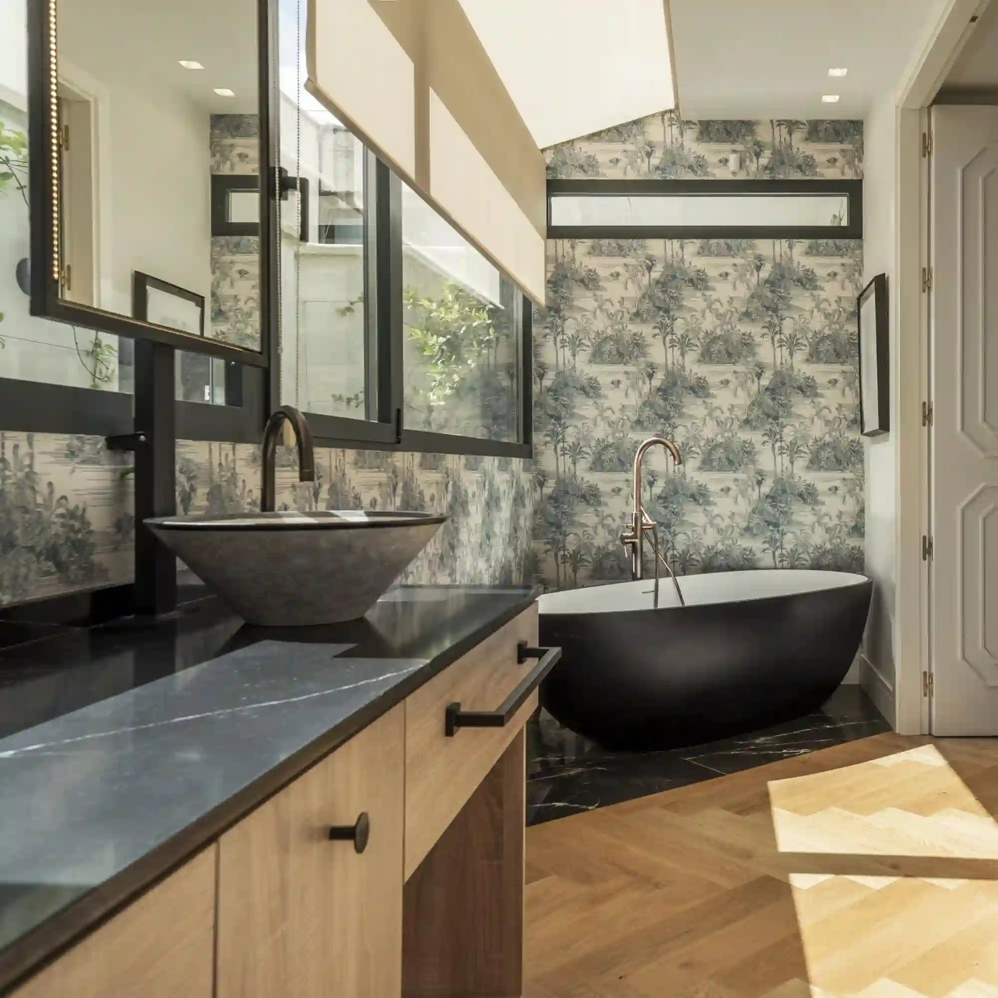 Book-matched marble vanity backsplash with mirrored veining pattern above a white vanity