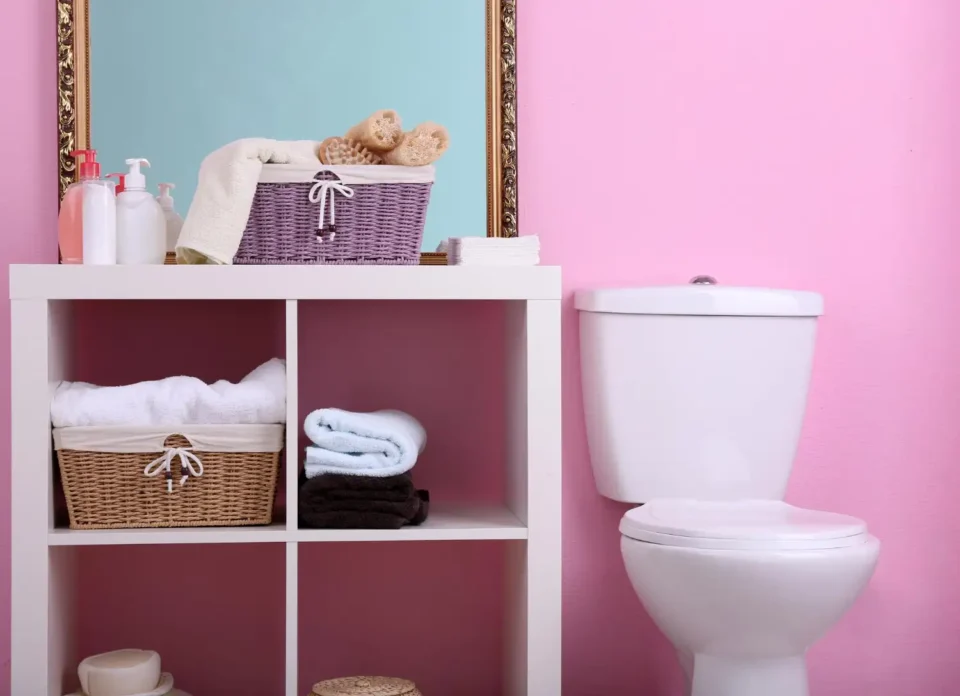 Small bathroom with a warm oak wall-mounted cabinet and floating shelves above a white toilet tank