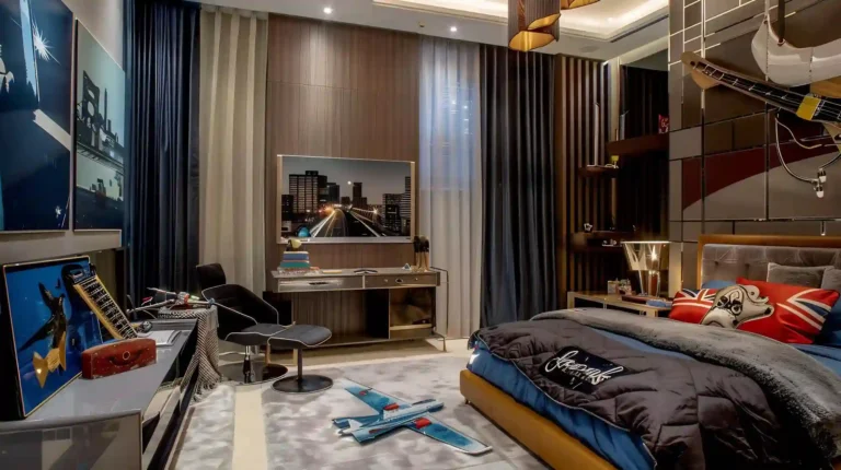 Guest-ready man cave with charcoal sleeper sofa, walnut media wall, rust rug, closed storage, and warm bedside lighting