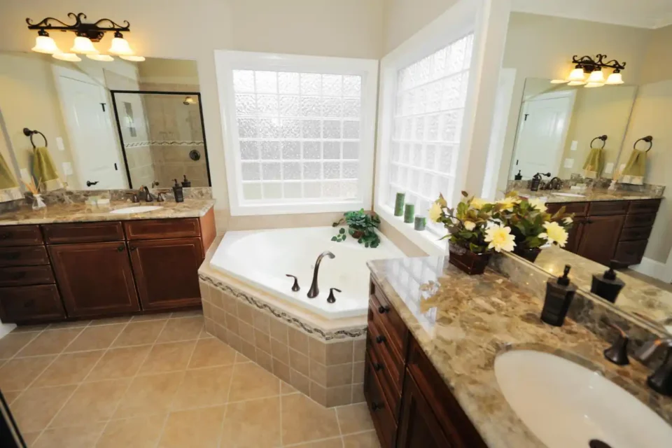 Elegant neutral bathroom with marble-look tile, brushed brass fixtures, and a simple floating vanity