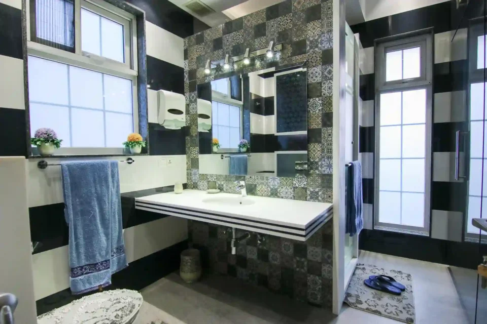 Tiny under-stairs half bathroom with sloped ceiling, light walls, and a compact 24-inch pedestal sink