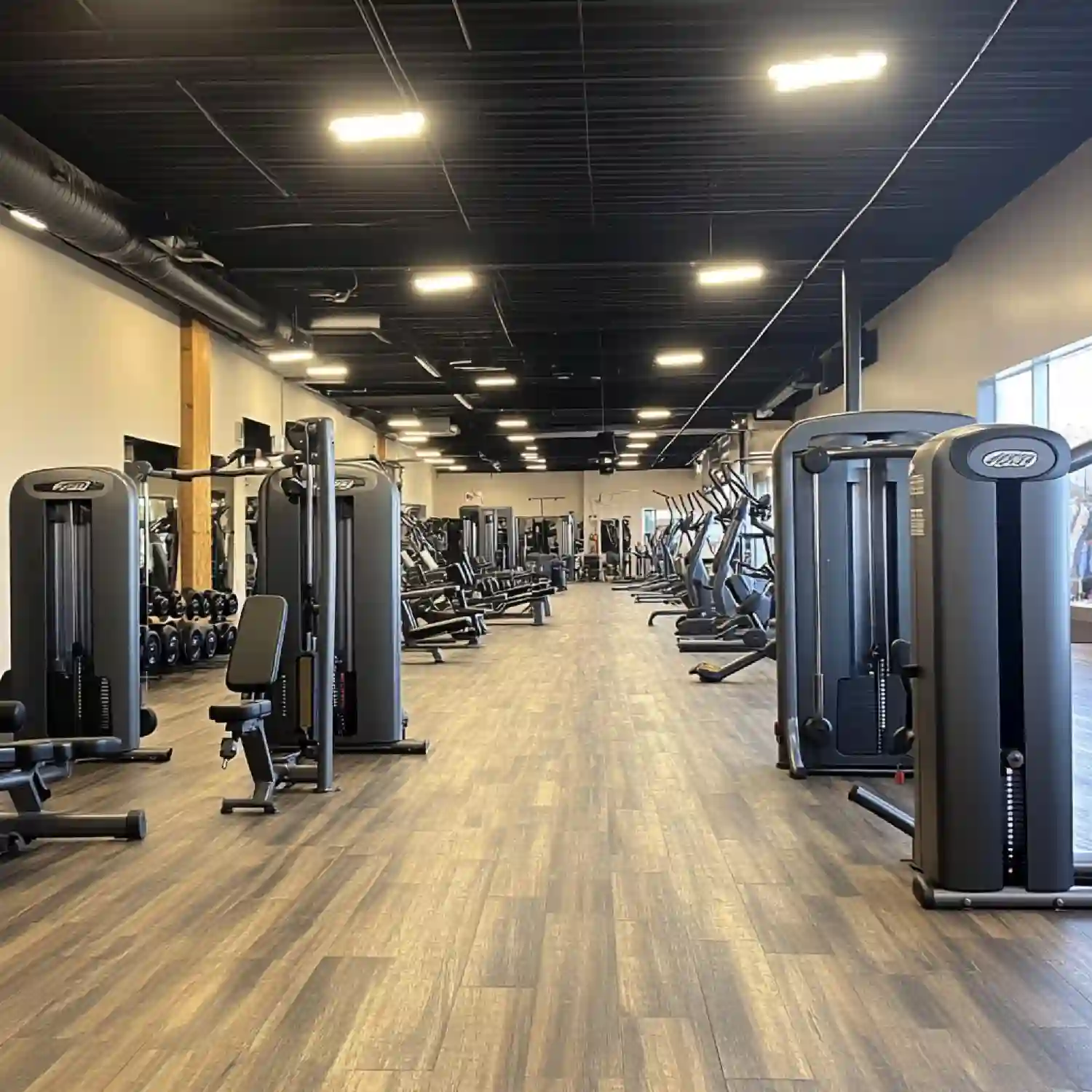 Artificial turf lane beside rubber flooring in a garage gym for sled pushes and mobility work
