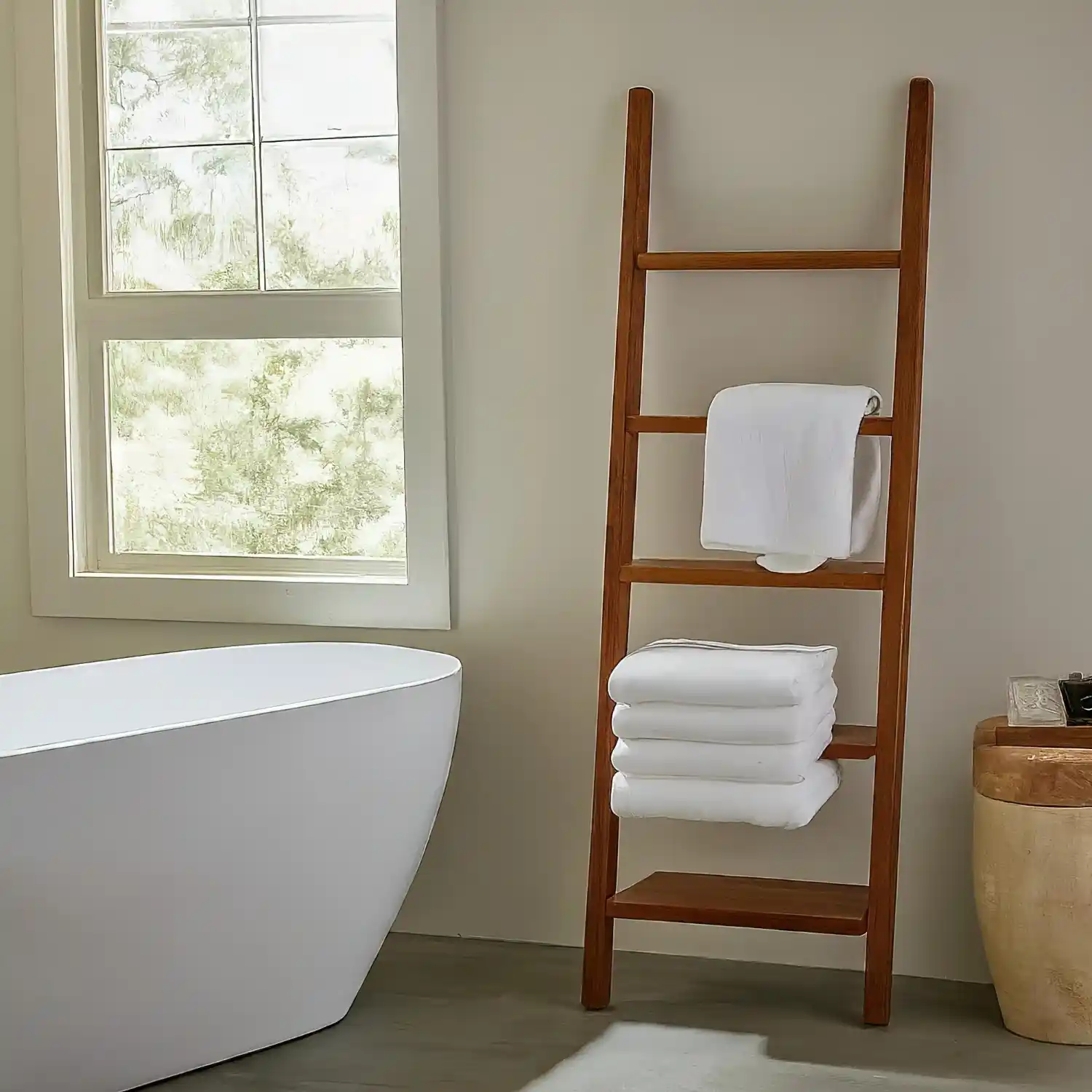 Wall-mounted towel rack with a top shelf holding folded towels and a small plant in a modern bathroom