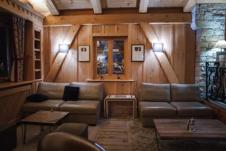 Rustic western man cave with reclaimed barn wood wall, cognac leather sofa, cowhide rug, and iron lantern lighting